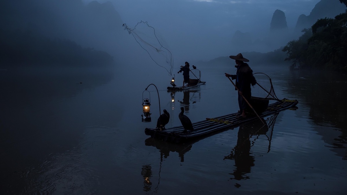 local fisherman in traditional costume standing on a boat