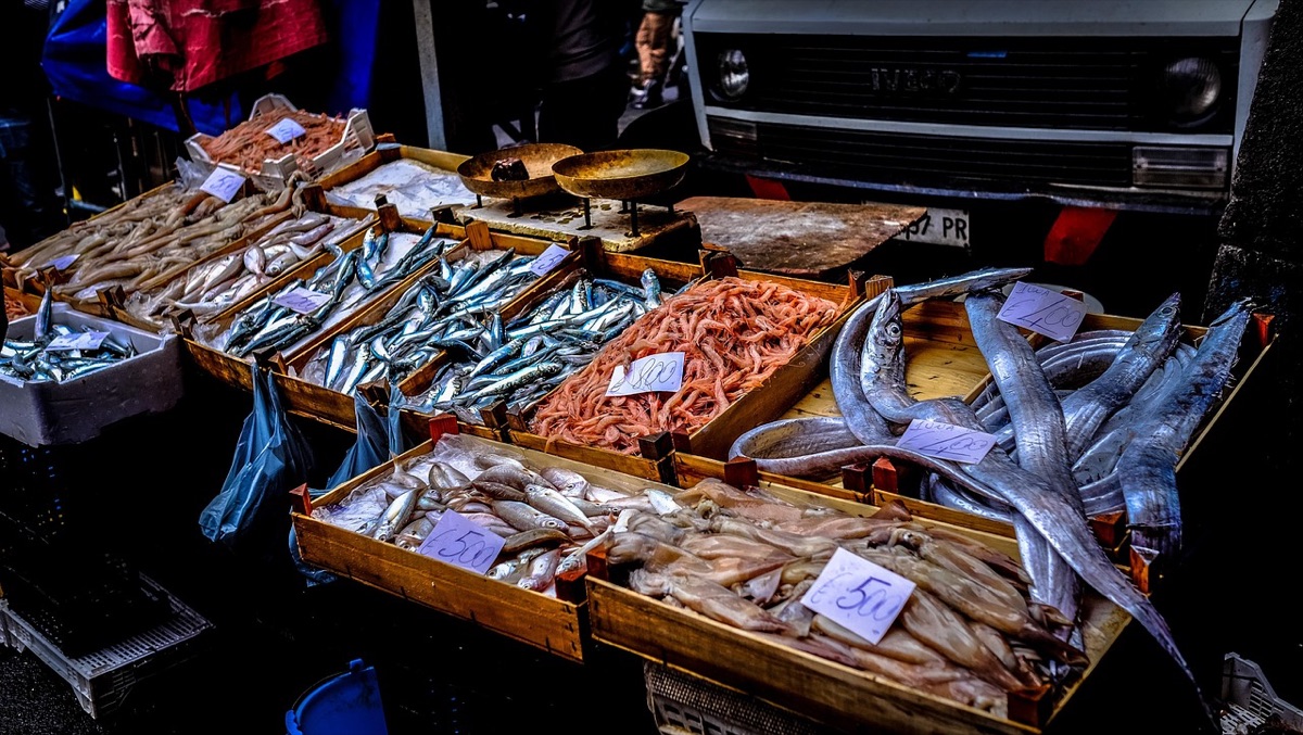Vue de dessus d'un marché de rue à Macau avec des stands et des produits locaux.